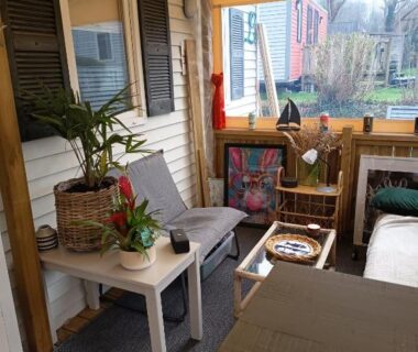Terrasse couverte avec salon extérieur plantes et coussins du Mobile home