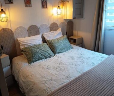 Chambre double avec lit coussins et éclairage chaleureux dans le mobile home