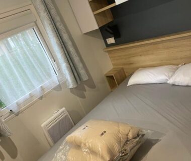 Chambre avec lit double et fenêtre dans le mobile home Les Viviers