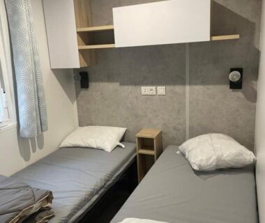 Chambre avec deux lits simples dans le mobile-home 6-8 personnes du camping Les Viviers