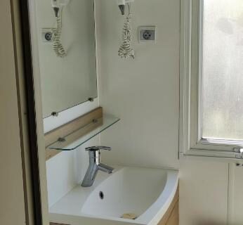 Salle d'eau avec lavabo et sèche-cheveux dans le mobile home 6 personnes Valras plage