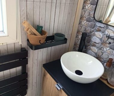 Salle de bain avec vasque ronde meuble miroir étagère accessoires dans le mobile home