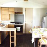 Intérieur avec cuisine équipée et table à manger dans le mobile home
