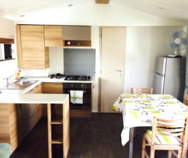 Intérieur avec cuisine équipée et table à manger dans le mobile home