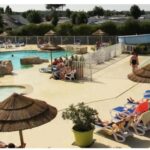 Piscine extérieure avec toboggans et parasols au Mobile-home Camping 4 etoiles bord de mer