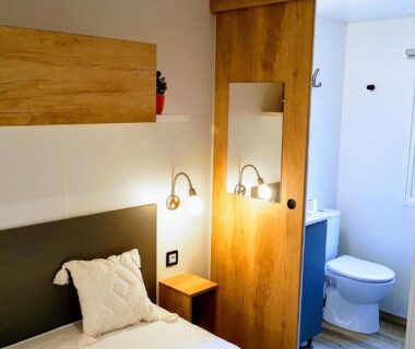 Intérieur chambre avec deux lits et salle d'eau du mobile home De Luxe St Cyprien