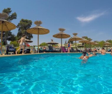 Piscine extérieure avec parasols et baigneurs au Mobile home De Luxe St Cyprien