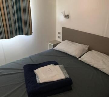 Chambre avec lit double et serviettes dans le mobile home Drôme homair