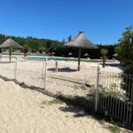 Aire de sable avec parasols et piscine au Mobile home Drôme homair