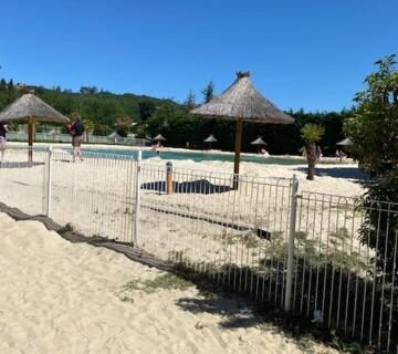 Aire de sable avec parasols et piscine au Mobile home Drôme homair
