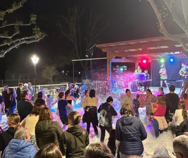 Espace d'animation nocturne avec foule et scène au mobile home Drôme homair