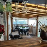Terrasse couverte avec table chaises et verres suspendus dans le mobile home Harley