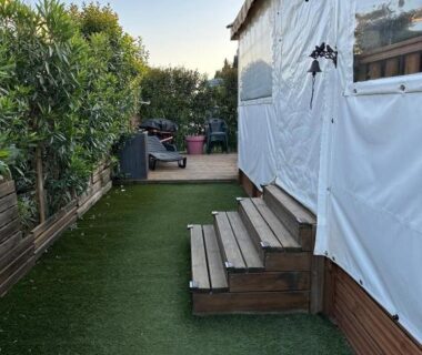 Dans le Var allée en gazon artificiel et marches en bois devant le mobile home Harley