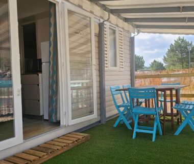 Terrasse avec table et chaises sur pelouse synthétique du mobile home Lacanau Ocean