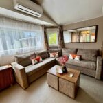 Salon avec canapés table basse et climatisation du Mobile home Myosotis camping siblu