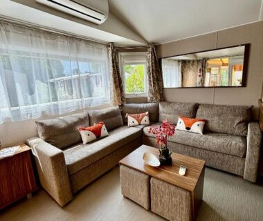 Salon avec canapés table basse et climatisation du Mobile home Myosotis camping siblu