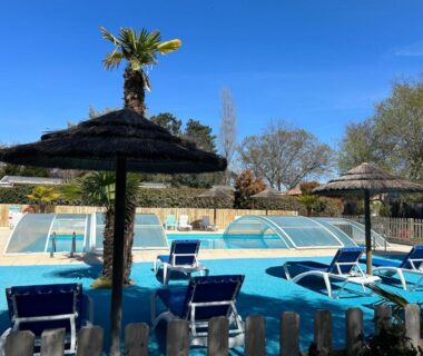 Piscine extérieure avec transats et parasols au Mobile home Premium 24m² 2 chambres
