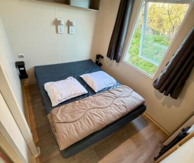Chambre avec lit double et fenêtre dans le mobile home Sol a gogo