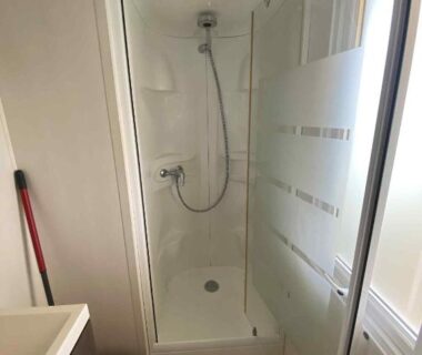 Salle d'eau avec douche et lavabo dans le Mobile home à Mimizan