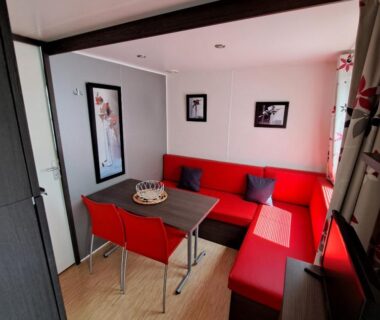 Intérieur avec banquette rouge et table à manger dans le mobile home à louer Les Sables d'Olonne Vendée