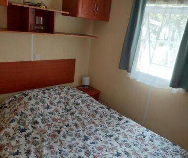 Chambre avec lit double et fenêtre dans le Mobile home camping Ardèche