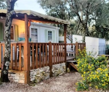 Terrasse en bois parmi les arbres du Mobile home camping Ardèche