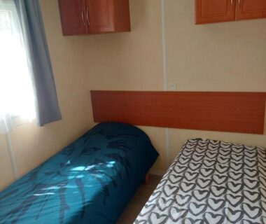 Chambre avec deux lits simples et rangements dans le Mobile home camping Ardèche