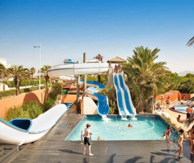 Piscine avec toboggans et palmiers au Mobile home canet en Roussillon