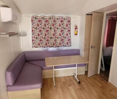 Coin salon avec banquette et table dans le mobile home climatisé