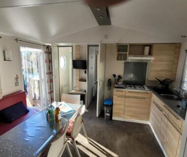 Intérieur avec salon et kitchenette du mobile-home confort 3 chambres au camping La Bourboule