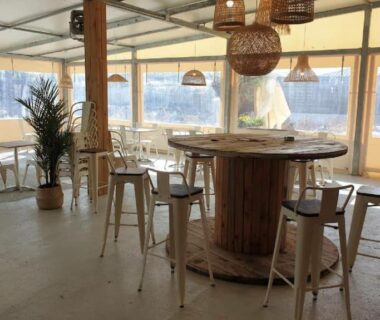 Terrasse couverte avec table et tabourets du mobile-home les pieds dans l'eau