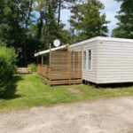 Terrasse en bois et pelouse ombragée du mobile home luxe au calme 6 pers 3 ch 2 sdb