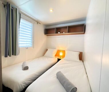 Chambre avec deux lits et lampe de chevet dans le mobile-home moderne Capbreton – Plage à 800m
