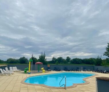 Piscine extérieure avec chaises longues et parasols au mobile home proche de Europa Park