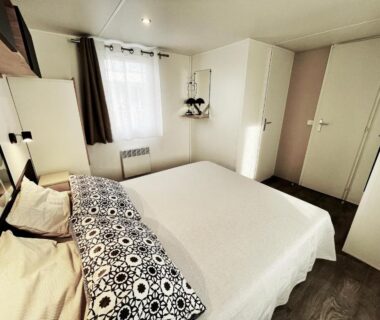 Chambre avec lit double et fenêtre dans le mobile-home Le Célestin