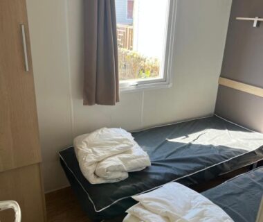 Chambre avec deux lits et fenêtre dans le Mobilehome