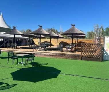 Espace extérieur avec parasols tables et pelouse du Mobilehome