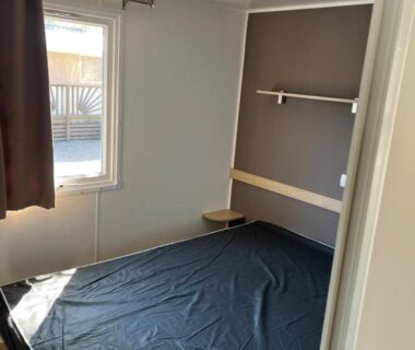 Chambre avec lit double et fenêtre dans le Mobilehome