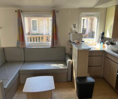 Salon avec banquette et kitchenette dans le Mobilehome