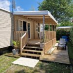 Terrasse en bois avec chaises et jardinet du Mobilehome familial