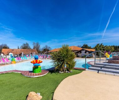 Piscine avec pataugeoire et espace vert dans le camping du Mobilehome familial