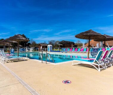 Piscine extérieure avec transats et parasols au Mobilehome familial