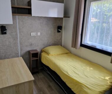 Chambre avec lit simple et fenêtre dans le mobilehome familial