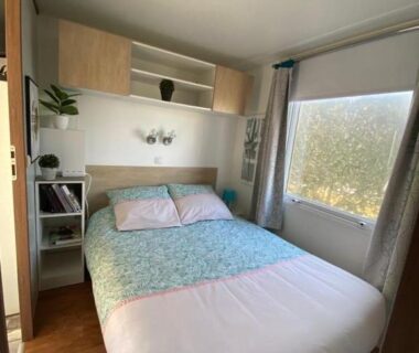 Intérieur chambre avec lit double et rangements dans le Mobilhom 143