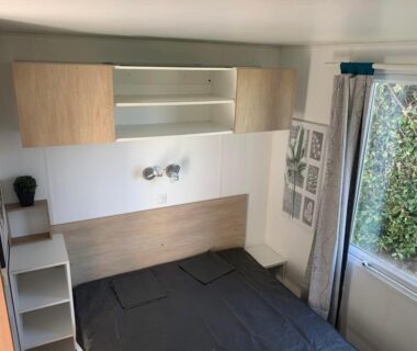 Chambre intérieure avec lit double et fenêtre dans le Mobilhom 143