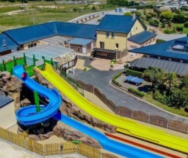 Aire aquatique du camping avec toboggans multicolores et bassins au Mobilhom 143