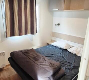 Chambre avec lit double et rangements dans le mobilhome