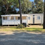 Allée gravillonnée et mobilhome sous les pins du Mobilhome
