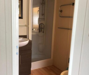 Salle de bain avec cabine de douche et lavabo dans le Mobilhome 2 Chambres 2 SDB