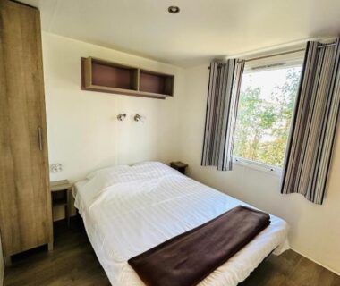 Chambre avec lit double et fenêtre dans le Mobilhome 228 proche du Lac